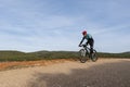 Man mountain biking in forest over a dirt track