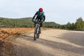 Man mountain biking in forest over a dirt track