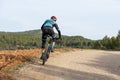 Man mountain biking in forest over a dirt track