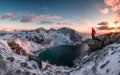 Man mountaineer standing on rock of peak mountain at sunset Royalty Free Stock Photo