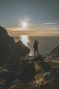 Man mountaineer tacking photography standing on rock of peak mountain at sunset. Ryten Mountain, Norway Royalty Free Stock Photo