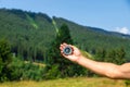 A man in the mountains holds a compass in her hands. Selective focus. Royalty Free Stock Photo