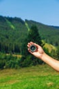 A man in the mountains holds a compass in her hands. Selective focus. Royalty Free Stock Photo