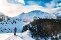 A man in the mountains. Ski touring on a split snowboard. A man stands with his back to the viewer and looks at the mountain Royalty Free Stock Photo