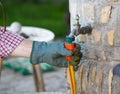 Man mounting hose to faucet in backyard Royalty Free Stock Photo