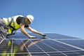 Man mounting modern solar batteries on house& x27;s roof. Environment friendly, green energy. Royalty Free Stock Photo