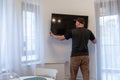 Man mounting new TV on the wall. Man installing television at home