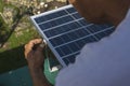 A man mounting a small 50 watt Polycrystalline solar panel on the eaves of a roof of a bungalow house Royalty Free Stock Photo