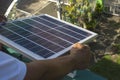 A man mounting a small 50 watt Polycrystalline solar panel on the eaves of a roof of a bungalow house Royalty Free Stock Photo