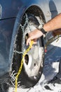 Man mounting snow chains on wheels