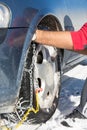 Man mounting snow chains on wheels