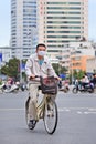 Man with mouth cap on a bike, Kunming, China