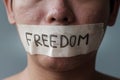 Man with mouth sealed in adhesive tape with Freedom message. Free of speech, freedom of press, Human rights, Protest dictatorship