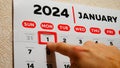 Close-up of a beautiful January page of the wall calendar 2024 and a male finger moves a red cursor to the New year\'s date