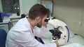 Man moves stage clipse on microscope at the laboratory