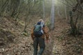 Man moves up the hill on fallen leaves in forest Royalty Free Stock Photo