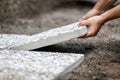 Man moves washed concrete slabs into a gravel bed