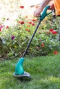 Man mowing grass lawn mower on the background of flower beds. Royalty Free Stock Photo