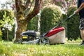 Man mowing grass by lawn mower at garden Royalty Free Stock Photo