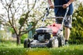 Man mowing grass by lawn mower at garden Royalty Free Stock Photo