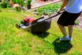 Man mowing the lawn with blue lawnmower in summertime closeup Royalty Free Stock Photo