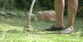 Man mowing lawn with electric grass trimmer machine