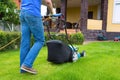 A man mowing a lawn with an electric mower in the garden backyard Royalty Free Stock Photo