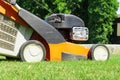 Man mowing the lawn with lawn mower in summer. Spring season sunny lawn mowing in the garden. Royalty Free Stock Photo