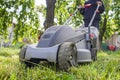 Man is mowing the lawn. Man with lawnmower is mowing green grass in the garden. Gardening Royalty Free Stock Photo