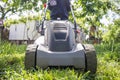 Man is mowing the lawn. Man with lawnmower is mowing green grass in the garden. Gardening Royalty Free Stock Photo