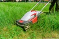 A man mows the grass with an electric lawn mower. Freshly mown grass Royalty Free Stock Photo