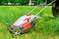 A man mows the grass with an electric lawn mower. Freshly mown grass Royalty Free Stock Photo