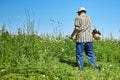 A man mows the grass in the field with a trimmer. Yard care concept. Royalty Free Stock Photo