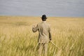 A man mows a grass with a scythe