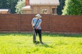 Man mows the grass with string trimmer Royalty Free Stock Photo