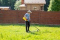 Man mows the grass with string trimmer Royalty Free Stock Photo