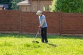 Man mows the grass with string trimmer Royalty Free Stock Photo