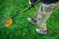 Man mows the grass with trimmer in the yard. Gardener mows a lawn Royalty Free Stock Photo