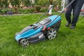 A man mows the lawn in his garden with an electric mower, close-up Royalty Free Stock Photo