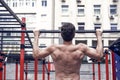 Man muscular back athlete doing pull ups with proper form, sport concept
