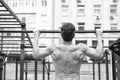 Man muscular back athlete doing pull ups with proper form, sport concept