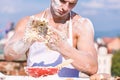 Man muscular baker or cook kneading dough in bowl. Hands of chef cook covered with sticky dough and flour. Bakery