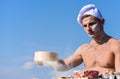 Man muscular baker or cook sifts flour through sieve. Baker working with flour and sieve, kneading dough. Hands of chef