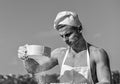 Man muscular baker or cook sifts flour through sieve. Pizzaiolo concept. Hands of chef cook covered with sticky dough