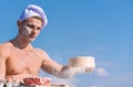 Man muscular baker or cook sifts flour through sieve. Baker working with flour and sieve, kneading dough. Hands of chef