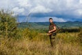 Man muscular brutal guy gamekeeper nature background. Hunter rifle gun stand top of mountain. Guy bearded hunter spend Royalty Free Stock Photo