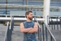 Man muscular fitness coach waiting on stairs stadium entrance background