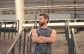 Man muscular fitness coach waiting on stairs stadium entrance background