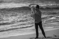 A man musician playing a tuba on the ocean beach. Black and white photo. Royalty Free Stock Photo