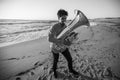 Man musician plays the tuba near the ocean. Black and white photo. Royalty Free Stock Photo